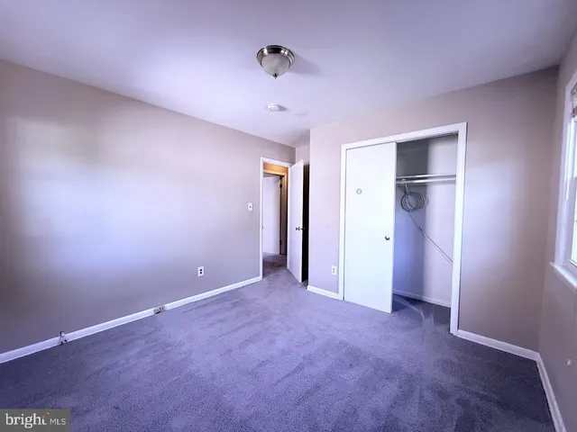an empty room with closet and entryway