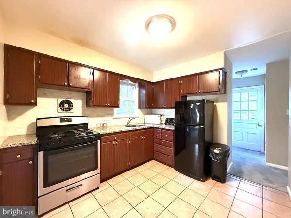a kitchen with stainless steel appliances granite countertop a refrigerator stove and sink