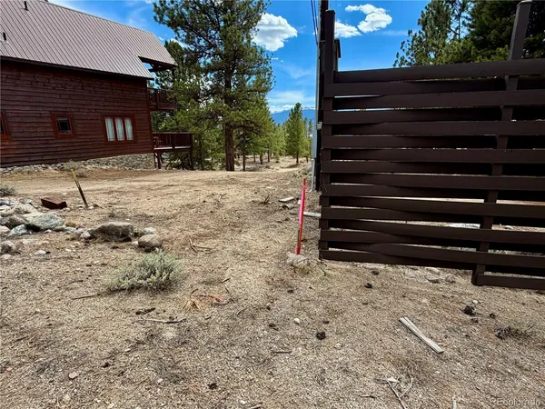 a view of a yard with wooden fence