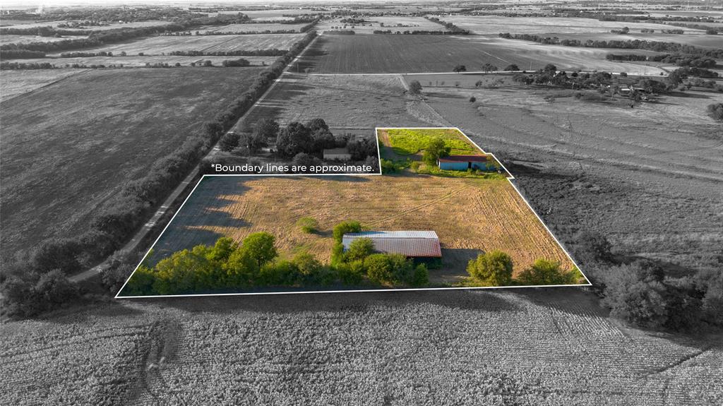 Aerial view of sparsely populated area with large plots for crops and property parcel outlined