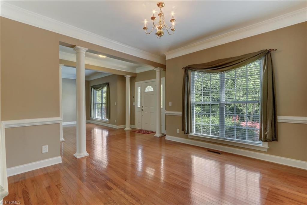 8302 Chartwell Drive Oak Ridge, NC 27310 - Photo 12 of 30 Dining room area with crown molding, high ceilings and large windows for more of that natural lighting.