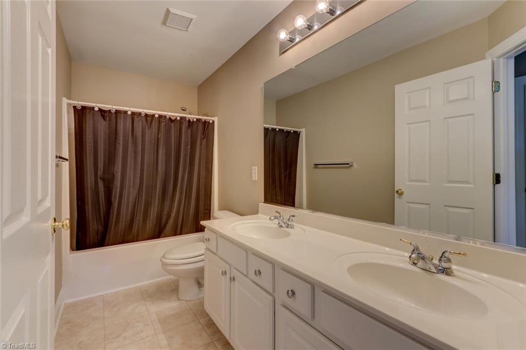 8302 Chartwell Drive Oak Ridge, NC 27310 - Photo 23 of 30 Second guest bathroom with double sinks and a bath and shower combination.