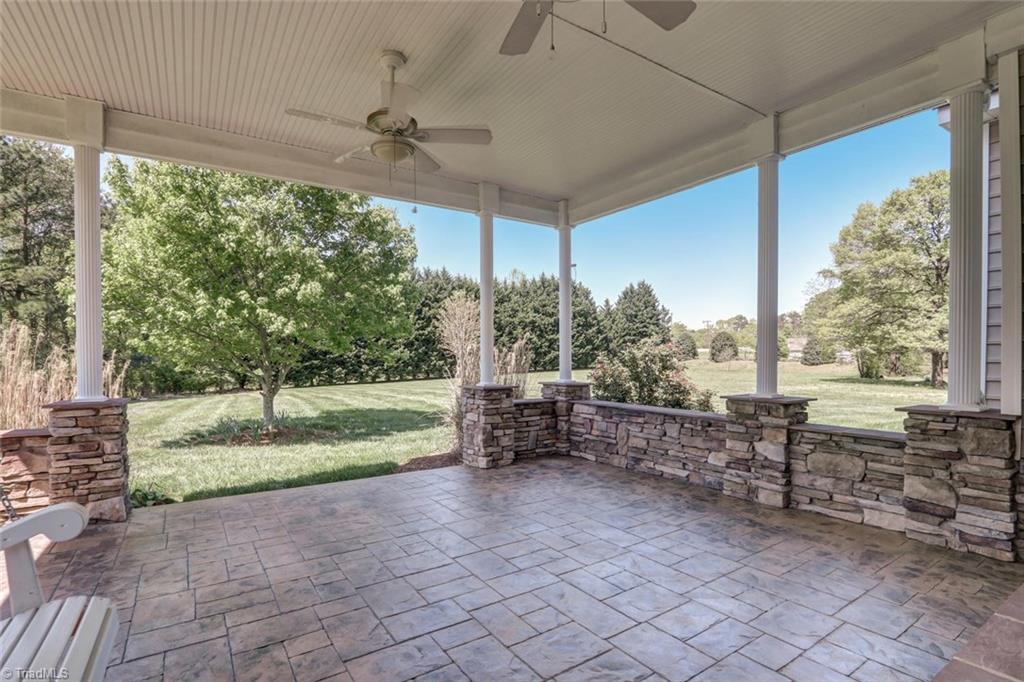 8302 Chartwell Drive Oak Ridge, NC 27310 - Photo 26 of 30 Gorgeous back patio with beautiful brick sidings, double ceiling fans and more of the columns you see throughout the home.