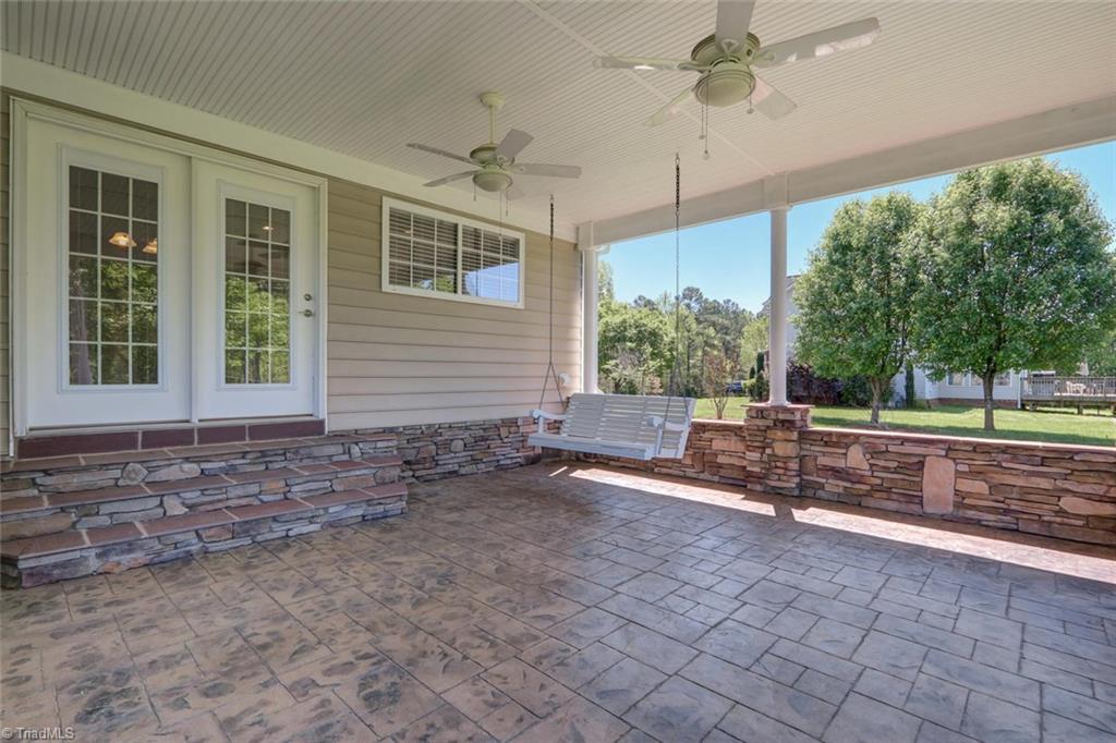 8302 Chartwell Drive Oak Ridge, NC 27310 - Photo 27 of 30 Second view of the patio with the entrance from the breakfast area and a nice outdoor swing.