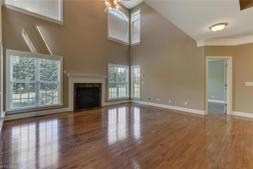 8302 Chartwell Drive Oak Ridge, NC 27310 - Photo 7 of 30 Great room and living space with many large windows for natural lighting as well as a gas fireplace, perfect for cold winters.