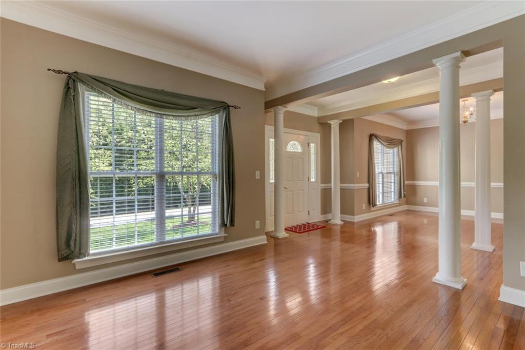 8302 Chartwell Drive Oak Ridge, NC 27310 - Photo 10 of 30 Formal living room area and a spacious foyer presenting nice columns to give the room a modern touch.