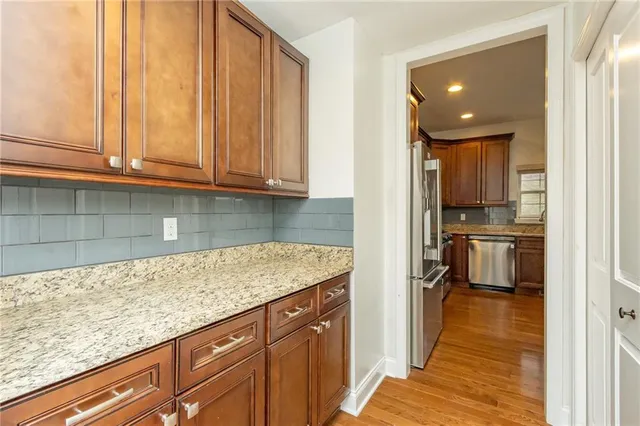 a kitchen with granite countertop kitchen island a sink stainless steel appliances and cabinets