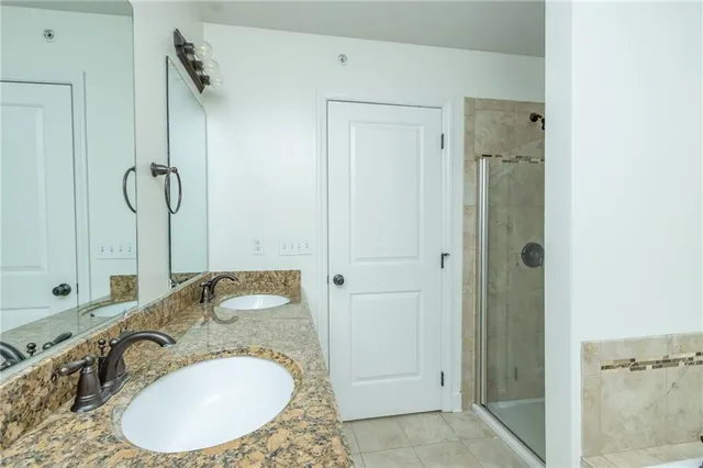a bathroom with a granite countertop shower sink and mirror