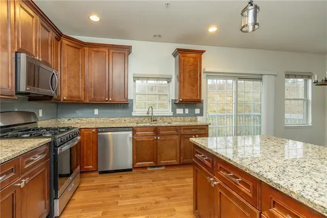 a kitchen with stainless steel appliances granite countertop a sink stove and cabinets