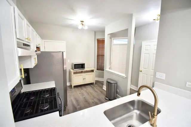 a kitchen with granite countertop a refrigerator a sink and dishwasher