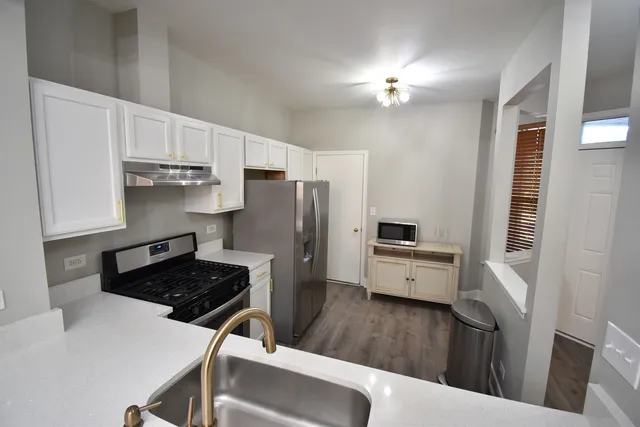 a kitchen with a refrigerator a stove top oven a sink and dishwasher