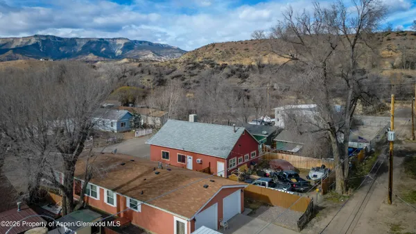 an aerial view of a house with a mountain
