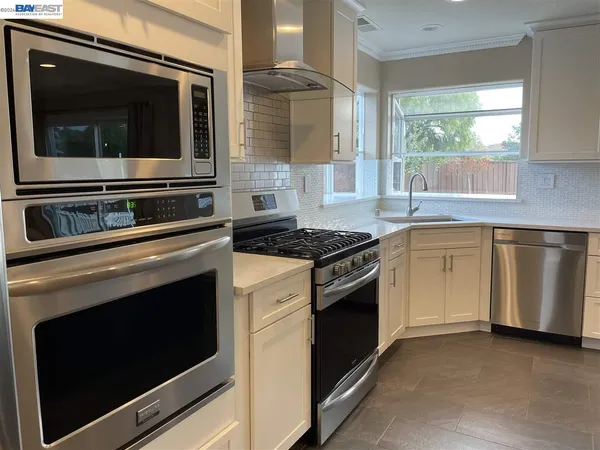 a kitchen with granite countertop a stove microwave and sink