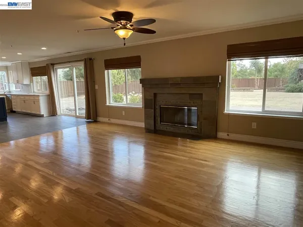 wooden floor fireplace and windows in an empty room