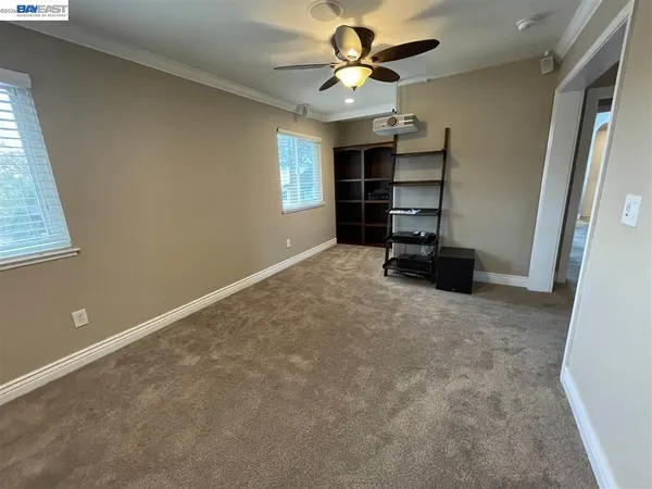 a view of a room with a ceiling fan and window