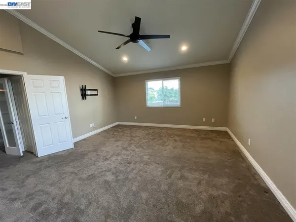 en empty room with windows and fan