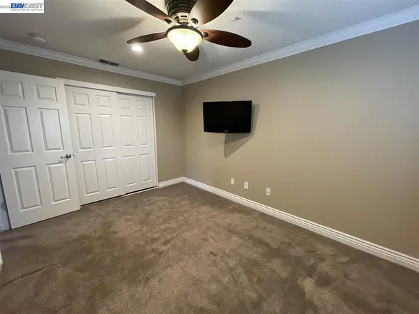 an empty room with a ceiling fan and a window