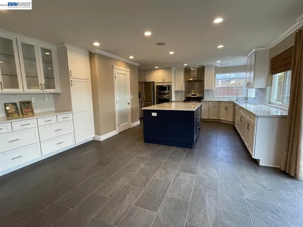 a large kitchen with stainless steel appliances granite countertop a refrigerator and a stove top oven