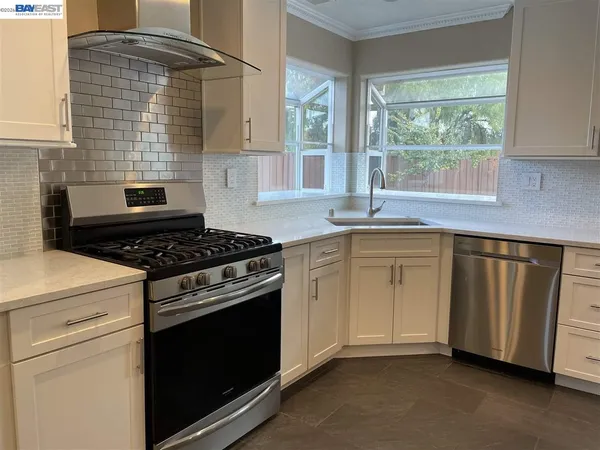 a kitchen with white cabinets and a stove top oven