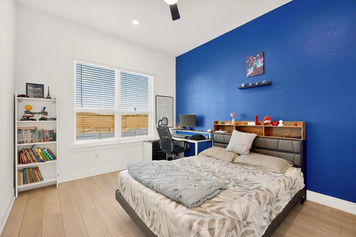 2121 Lolo Lane Leander, TX 78641 - Photo 15 of 26 Bedroom featuring light wood finished floors, a ceiling fan, and an office area