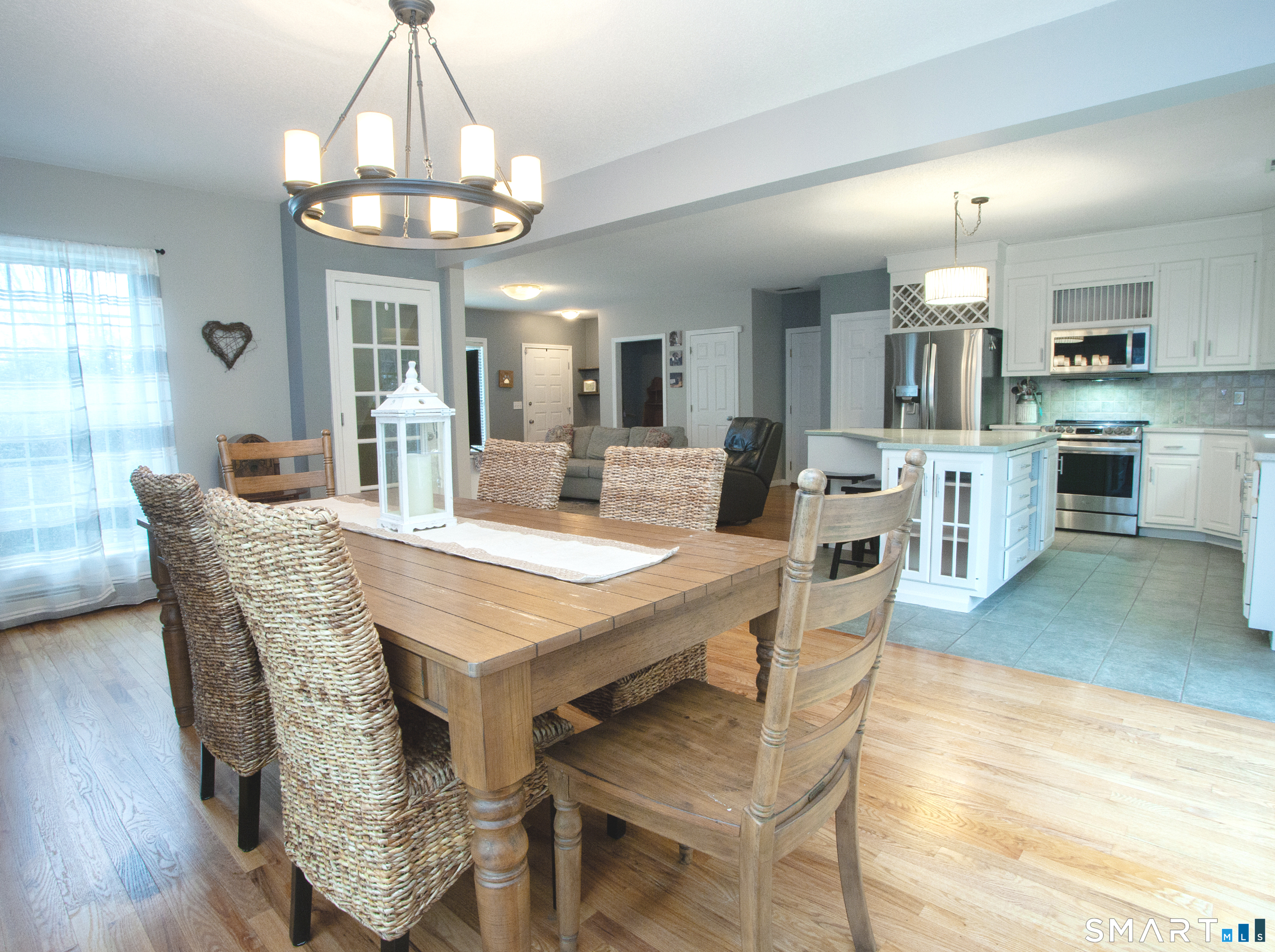 15 Rockledge Lane Canton, CT 06019 - Photo 4 of 30 a dining room with wooden floor a chandelier a wooden table and chairs