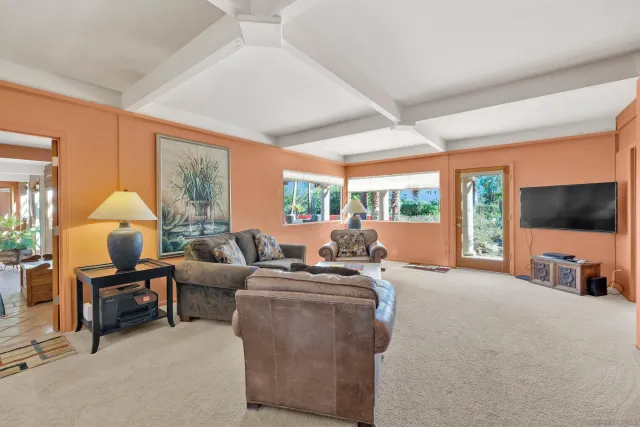 a living room with furniture a flat screen tv and a large window