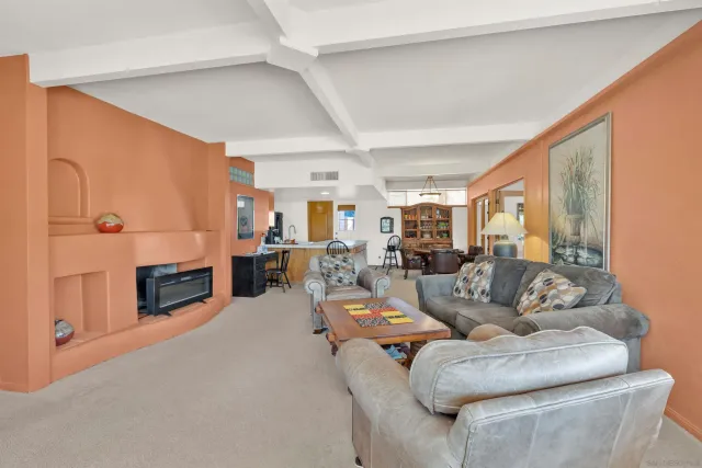a living room with furniture large window and fireplace