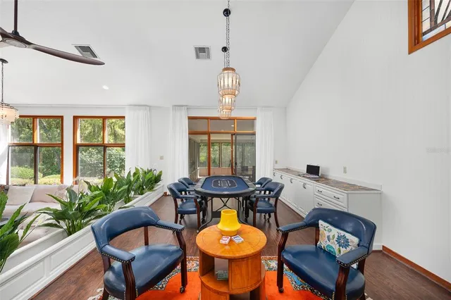 a dining hall with stainless steel appliances kitchen island granite countertop a table and chairs in it