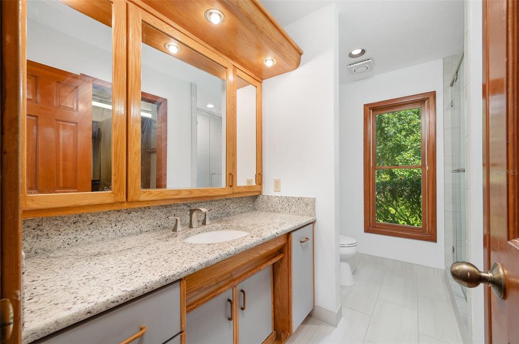 413 Southwest 97 Terrace Gainesville, FL 32607 - Photo 35 of 67 a bathroom with a granite countertop sink and a mirror