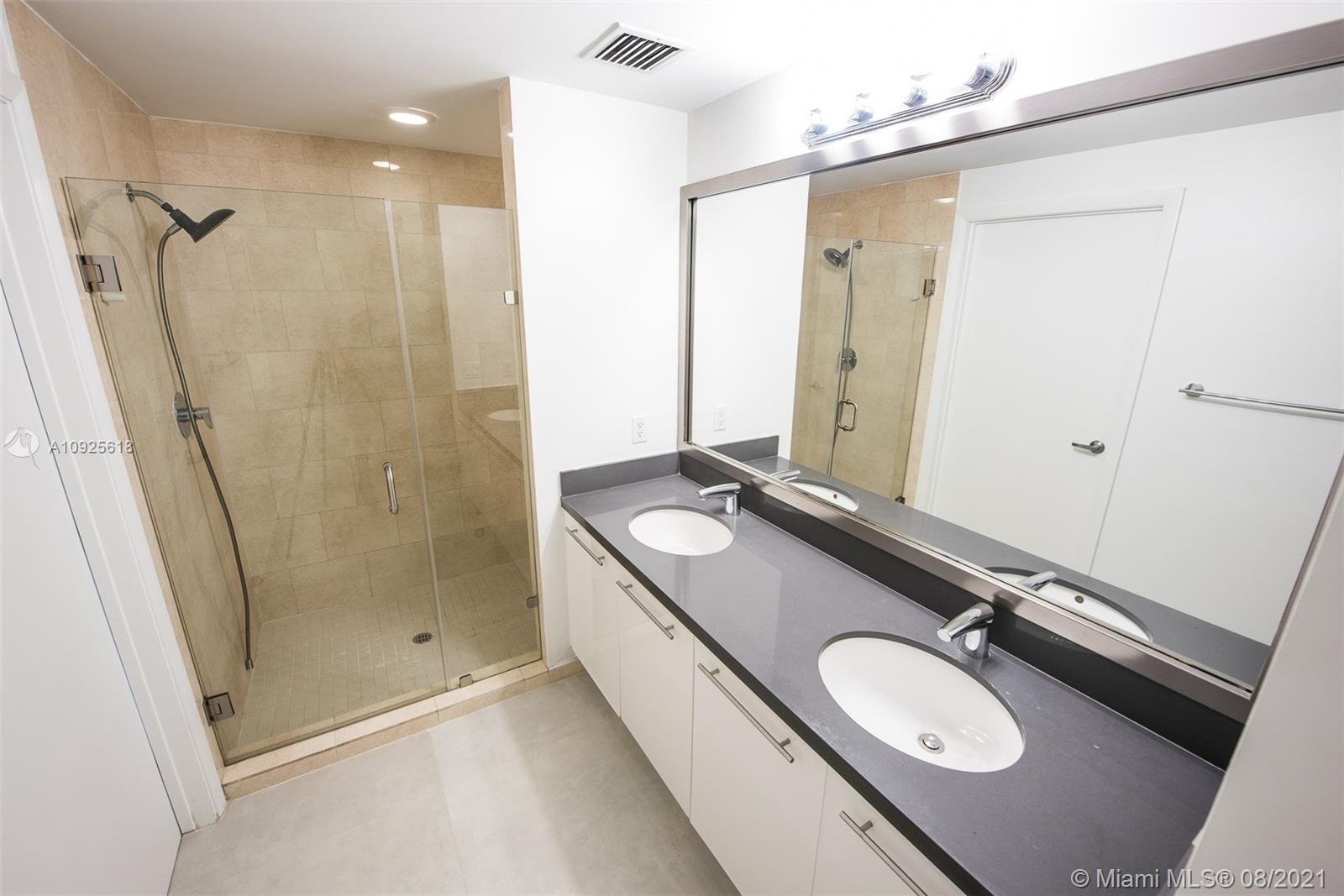 90 Southwest 3rd Street, Unit 2411 Miami, FL 33130 - Photo 12 of 22 a bathroom with a sink double vanity mirror and shower