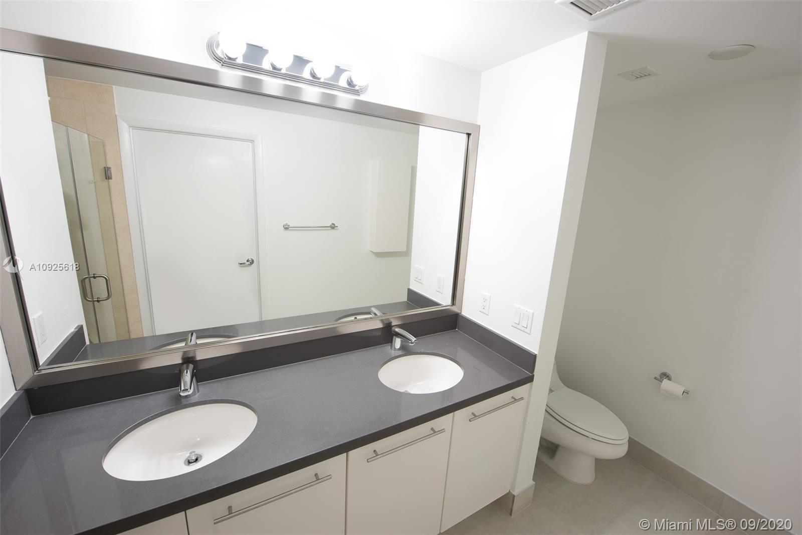 90 Southwest 3rd Street, Unit 2411 Miami, FL 33130 - Photo 13 of 22 a bathroom with a granite countertop sink and a mirror