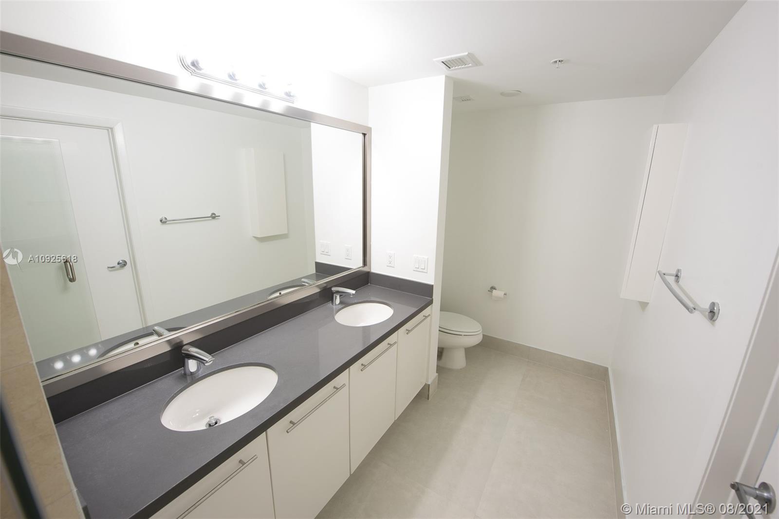 90 Southwest 3rd Street, Unit 2411 Miami, FL 33130 - Photo 14 of 22 a bathroom with a granite countertop sink and a mirror