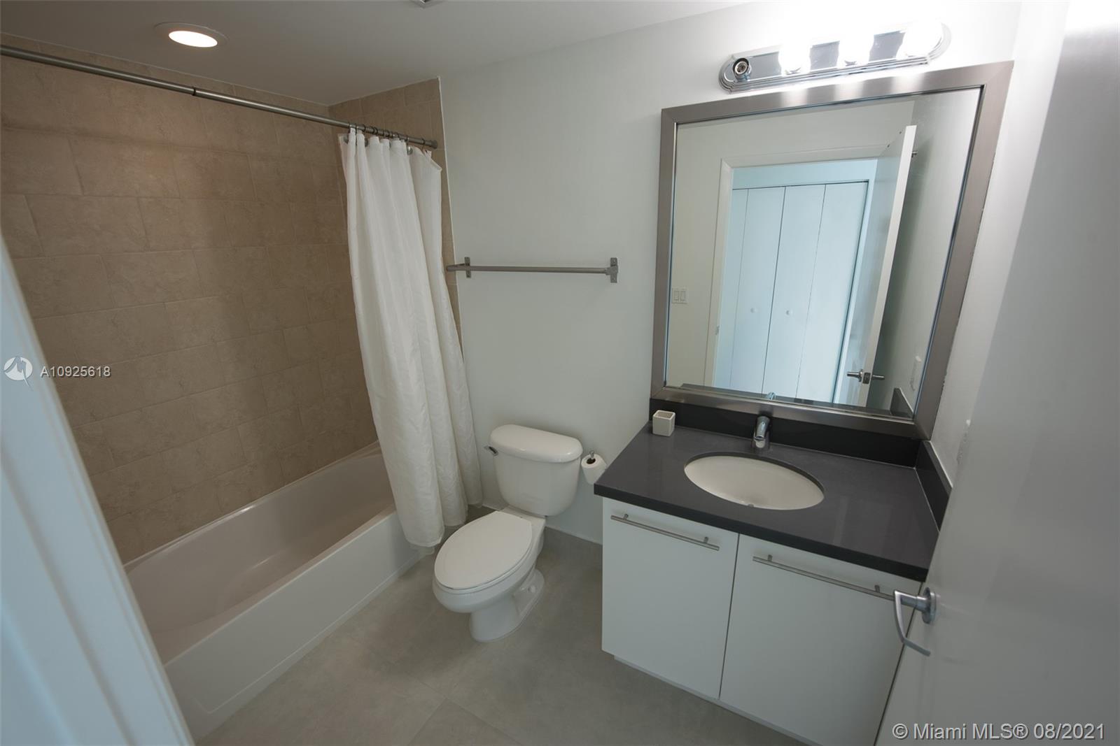 90 Southwest 3rd Street, Unit 2411 Miami, FL 33130 - Photo 19 of 22 a bathroom with a granite countertop sink toilet and shower