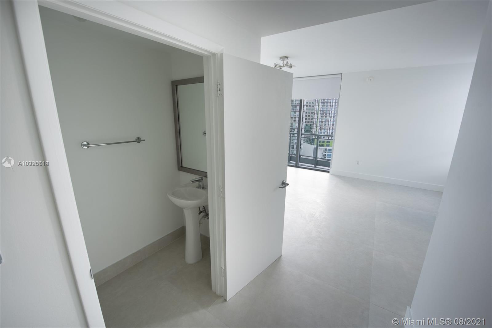 90 Southwest 3rd Street, Unit 2411 Miami, FL 33130 - Photo 8 of 22 a view of an empty room with wooden floor and a bathroom