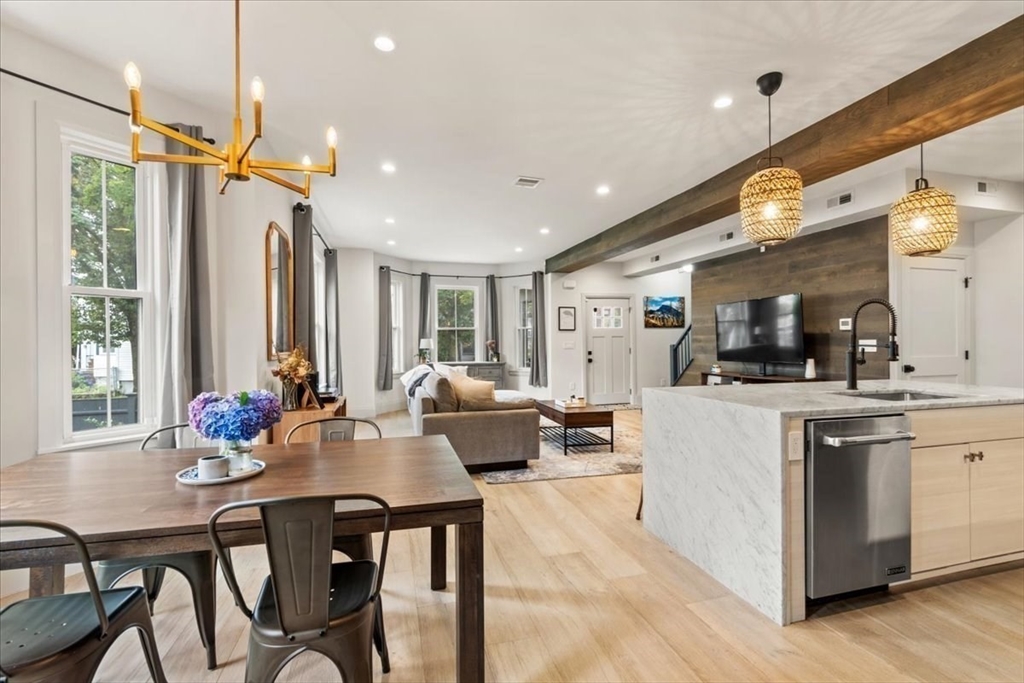 3 Adrian Street, Unit 3 Somerville, MA 02143 - Photo 5 of 31 a view of a dining room and livingroom with furniture wooden floor a chandelier