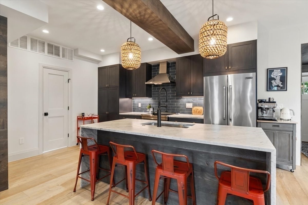 3 Adrian Street, Unit 3 Somerville, MA 02143 - Photo 7 of 31 a kitchen with stainless steel appliances granite countertop a sink refrigerator dining table and chairs