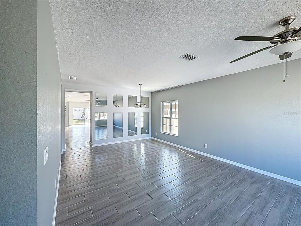 469 Ogelthorpe Drive Davenport, FL 33897 - Photo 3 of 10 a view of empty room with wooden floor and fan