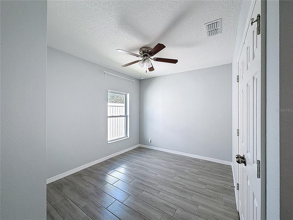 469 Ogelthorpe Drive Davenport, FL 33897 - Photo 8 of 10 wooden floor in an empty room with a window