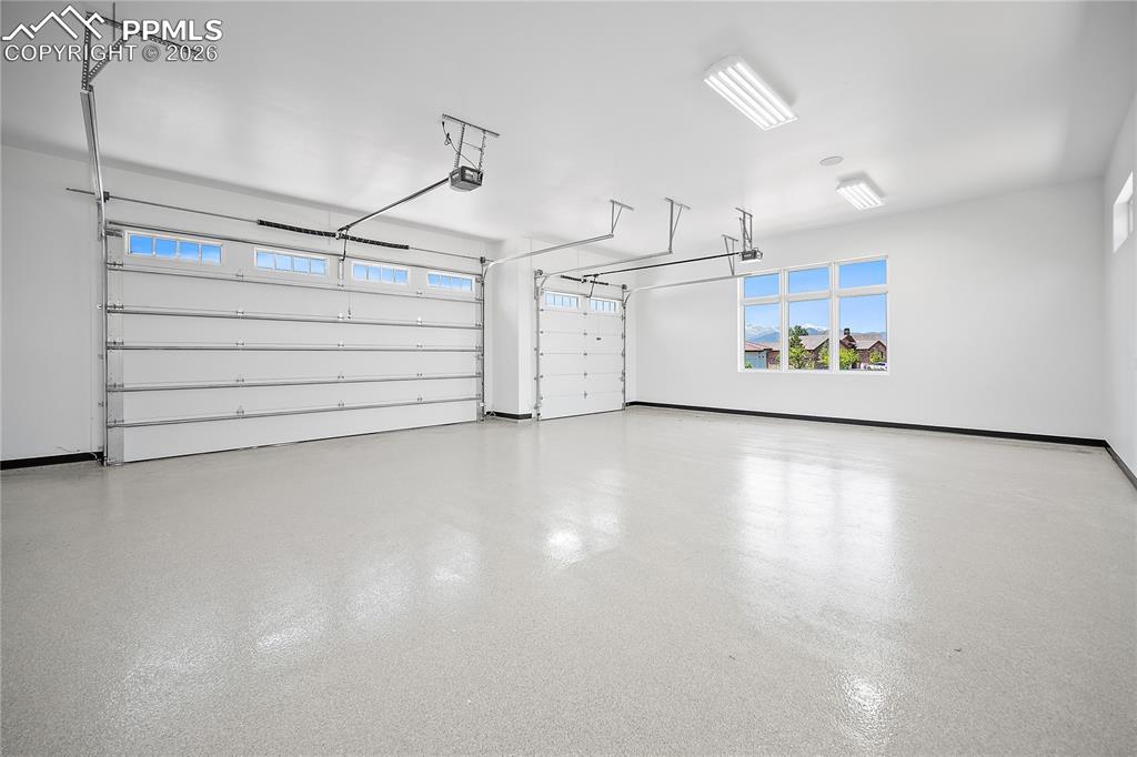 13525 Random Ridge View Colorado Springs, CO 80921 - Photo 38 of 43 An oversized three-car garage that is fully drywalled and insulated, featuring an epoxy-coated floor and a separate central vacuum system for added convenience.