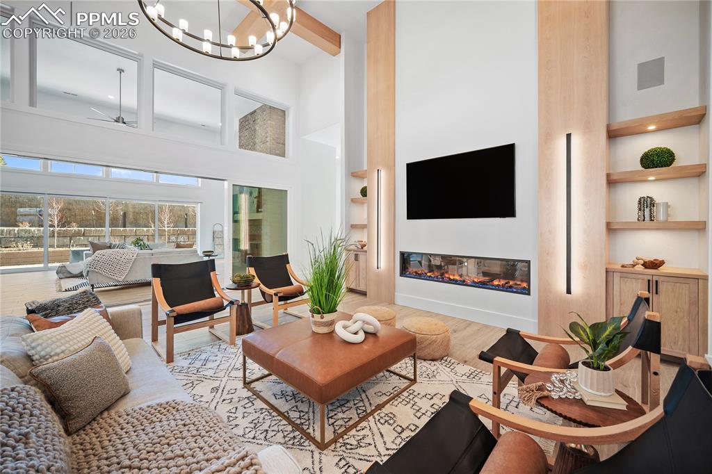13525 Random Ridge View Colorado Springs, CO 80921 - Photo 7 of 43 An open floor plan with soaring 18-foot ceilings, highlighted by a striking electric fireplace and comfortable radiant heated floors.