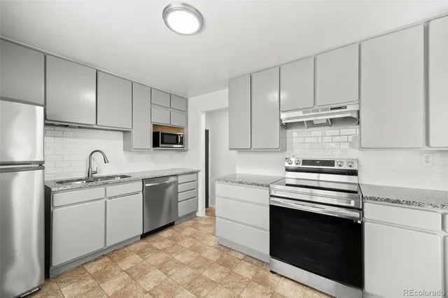a kitchen with cabinets appliances and a sink