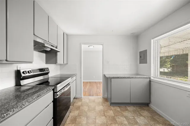a kitchen with stainless steel appliances granite countertop a sink stove and cabinets