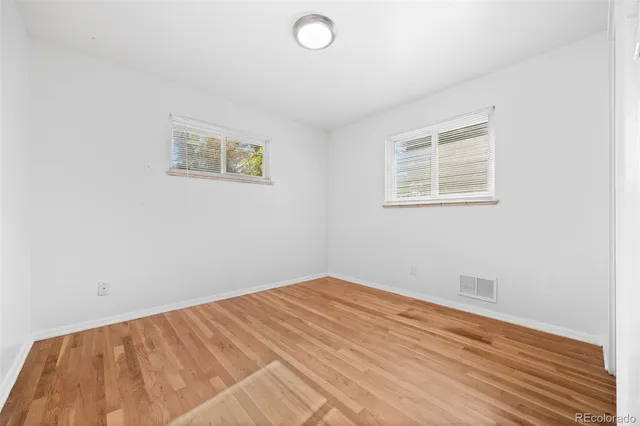 a view of empty room with wooden floor