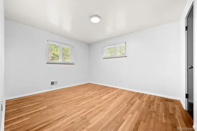a view of empty room with wooden floor