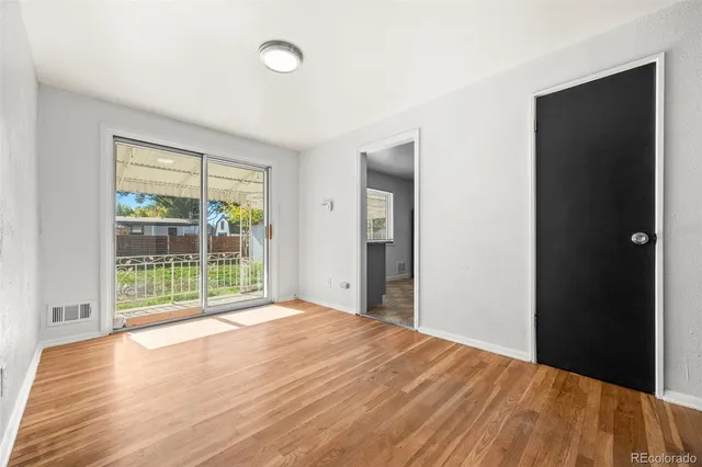 a view of a room with wooden floor and a window