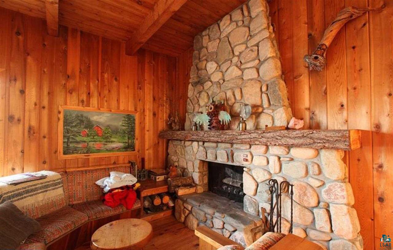 3-4 Wakemup Narrows North Cook, MN 55723 - Photo 11 of 41 Living room featuring wooden ceiling, beam ceiling, wood-type flooring, wood walls, and a stone fireplace