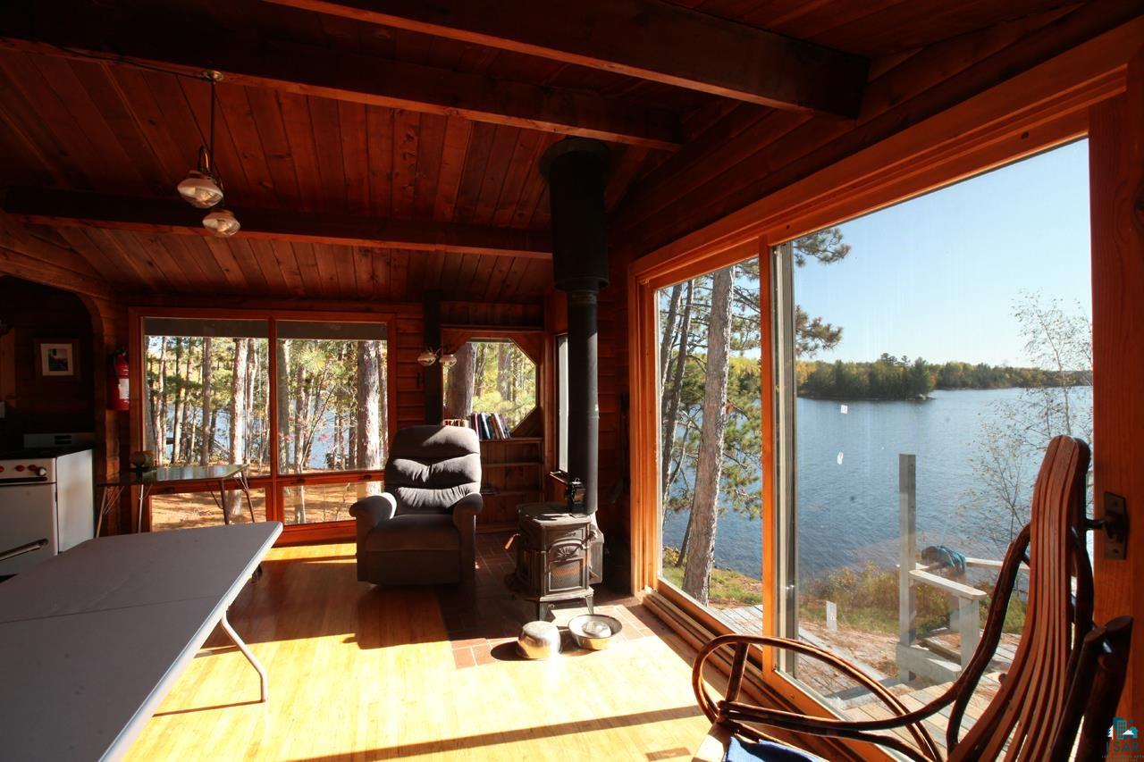 3-4 Wakemup Narrows North Cook, MN 55723 - Photo 13 of 41 Sunroom with a wood stove, wood ceiling, vaulted ceiling with beams, and a water view