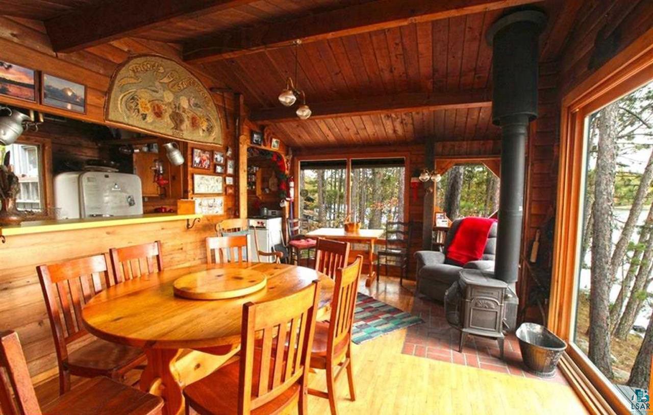 3-4 Wakemup Narrows North Cook, MN 55723 - Photo 14 of 41 Dining space with vaulted ceiling with beams, wooden walls, a wood stove, and wooden ceiling