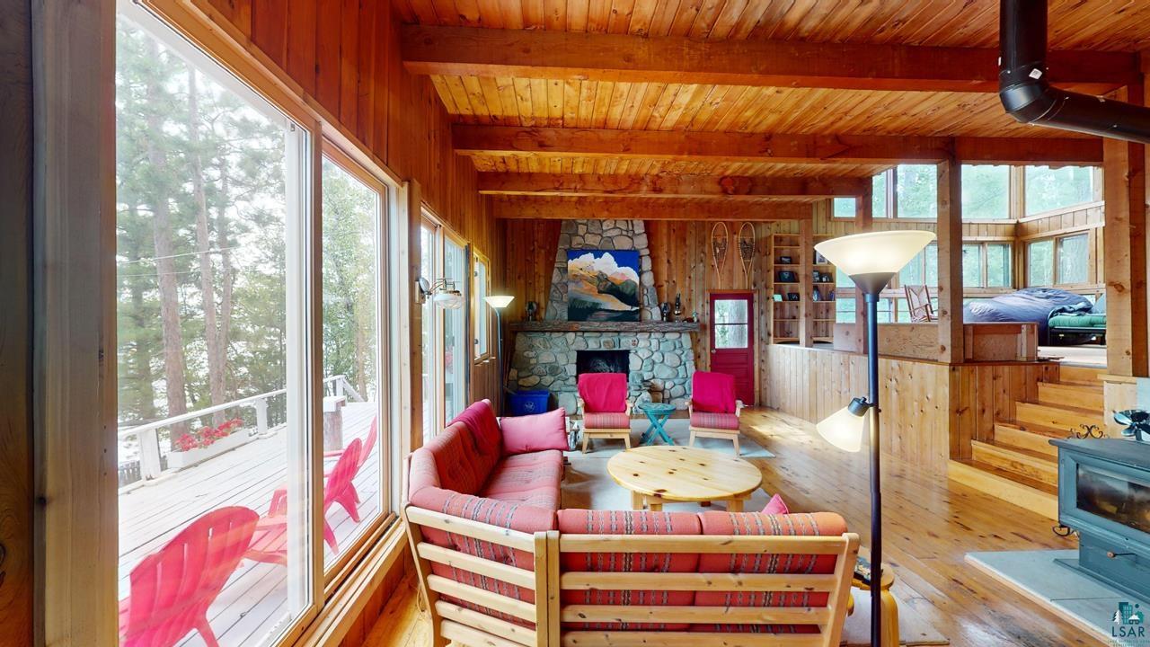 3-4 Wakemup Narrows North Cook, MN 55723 - Photo 10 of 41 Sunroom with a wood stove, a healthy amount of sunlight, and wood ceiling