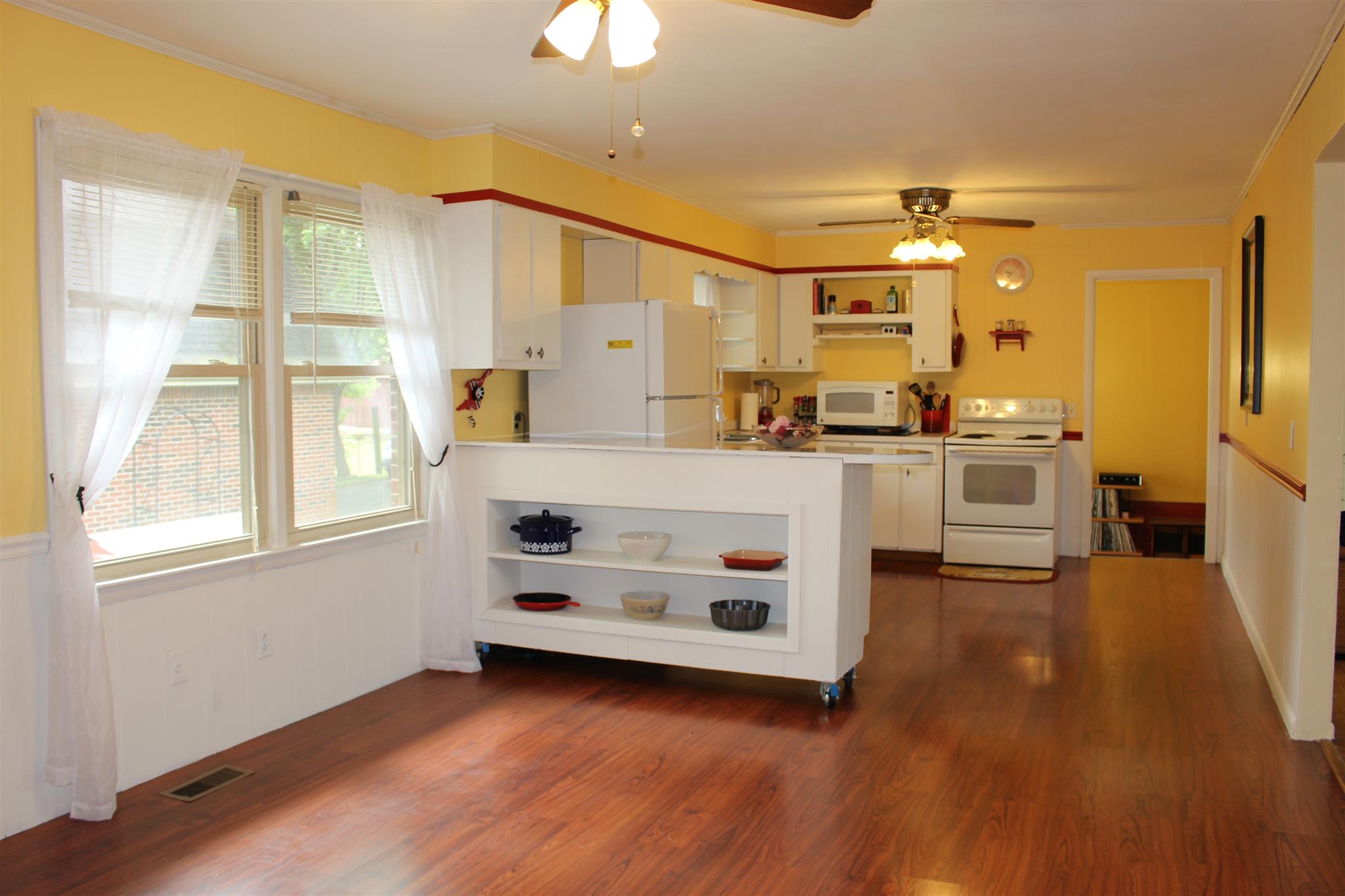 6740 Summitville Road Morrison, TN 37357 - Photo 8 of 30 a kitchen with stainless steel appliances a stove a sink and white cabinets with wooden floor